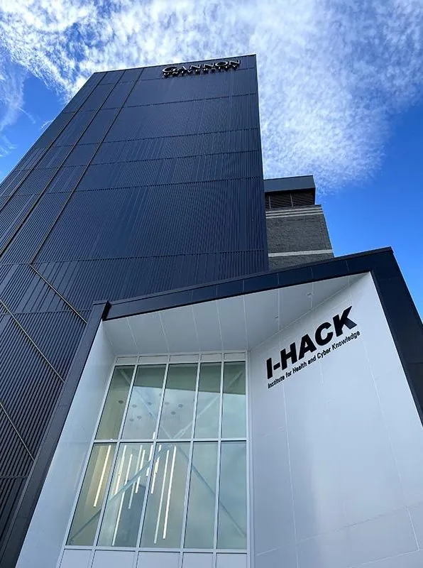 Gannon's I-HACK building, the Institute for Health and Cyber Knowledge, seen from below against a blue sky.
